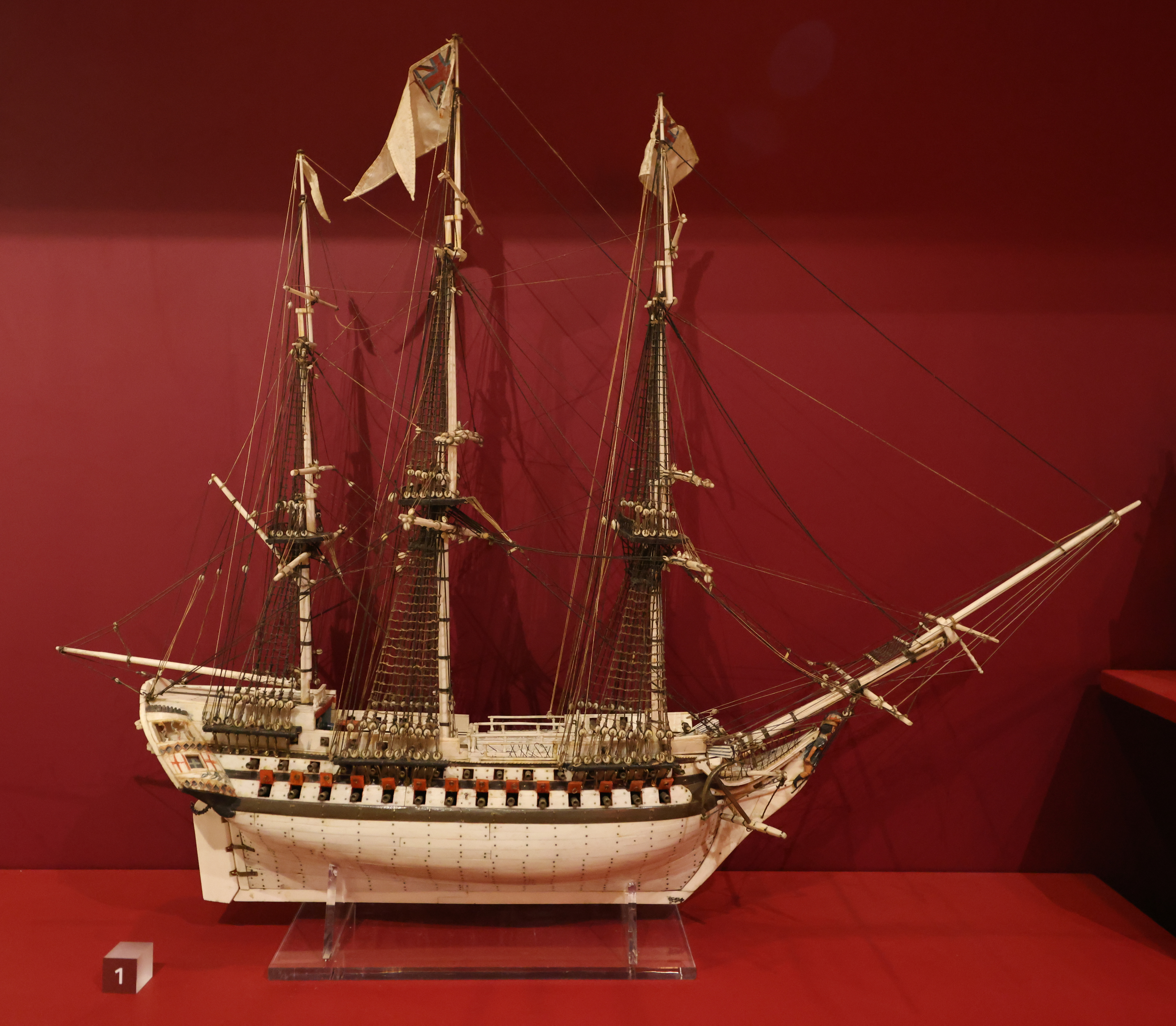 Detailed model sailing warship made from bone by a French prisoner of war, with three masts, rigging and a pale carved hull.